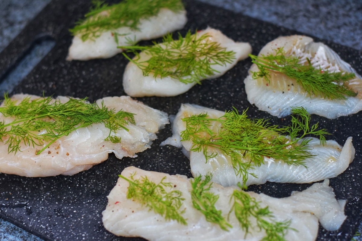 Fischfilets mit frischen Dill belegen